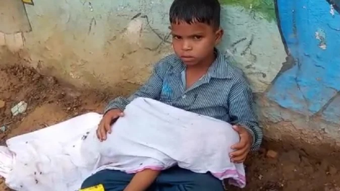 दो साल के छोटे भाई का शव गोद में लेकर सड़क पर बैठा मासूम